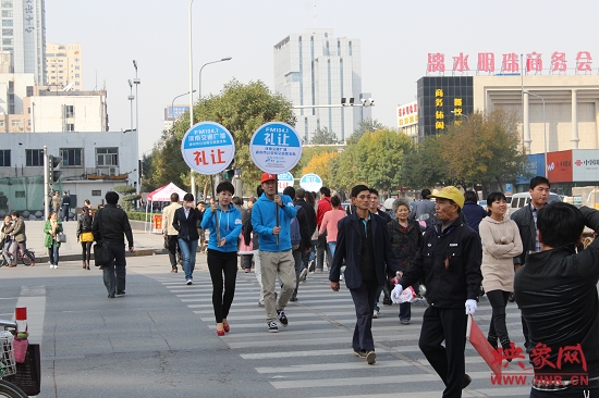 河南交通廣播的主持人們引導(dǎo)過(guò)馬路的行人從斑馬線(xiàn)通行