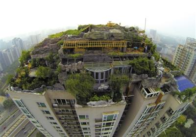 　　昨日，身穿橘黃色馬甲的工作人員在人濟山莊樓頂拆除違章建筑。新京報記者 吳江 攝