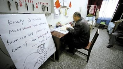 張大爺在門衛(wèi)室里工作，旁邊是紅爆網(wǎng)絡(luò)的溫馨提示牌記者