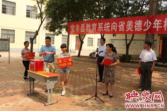 寶豐縣教育系統(tǒng)全體人員在石橋鎮(zhèn)中學(xué)為“美德少年”楊冠明同學(xué)捐款。