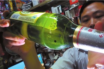 這瓶未開封的燕京啤酒內(nèi)有一顆黑色懸浮物。京華時(shí)報(bào)記者 徐曉帆 攝