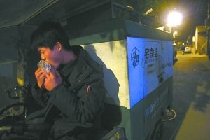 快遞哥抽空吃兩口東西。記者 李剛 攝
