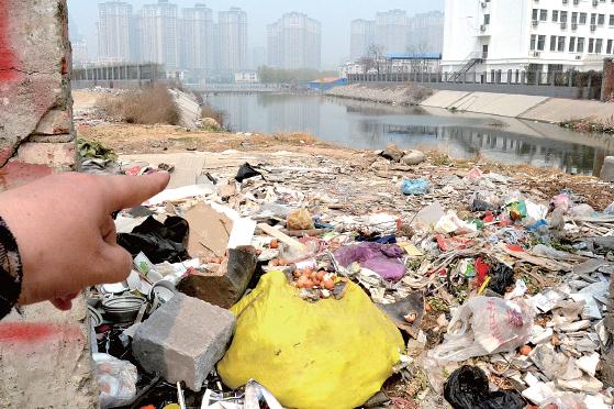 金水河長(zhǎng)江路橋下河水發(fā)臭，水邊堆放眾多垃圾