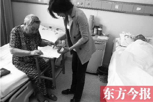 昨日，鄭大五附院二號樓住院部，馬老太寫下委托書，并簽字摁指印委托女兒代理為昏迷老伴解鎖取錢