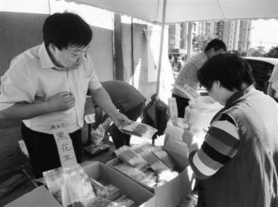 昨日，河南企業(yè)家劉春喜在京“練攤”，為顧客挑選綠豆。新京報(bào)記者 張玉學(xué) 攝