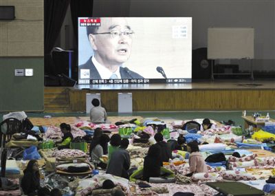 27日，韓國(guó)珍島，“歲月”號(hào)客輪乘客家屬在體育館觀看總理鄭烘原辭職新聞。當(dāng)日，鄭烘原召開(kāi)緊急發(fā)布會(huì)，表示對(duì)韓國(guó)“歲月”號(hào)沉船事件負(fù)責(zé)，宣布引咎辭職。