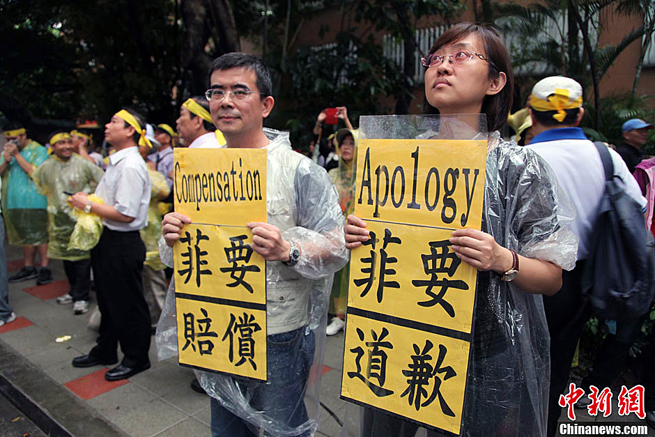 　圖為當(dāng)天下午，當(dāng)臺(tái)灣數(shù)百漁民在馬尼拉經(jīng)濟(jì)文化辦事處前抗議時(shí)，有兩名年輕人手持標(biāo)語(yǔ)，在路邊聲援。中新