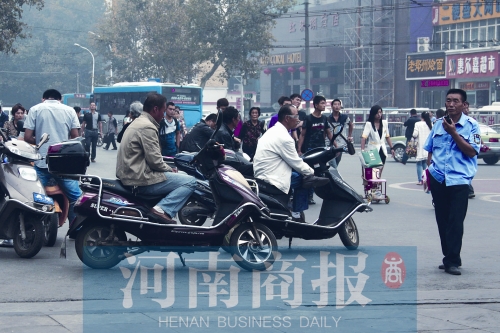 　火車站廣場北側(cè)，幾輛摩的正在等客