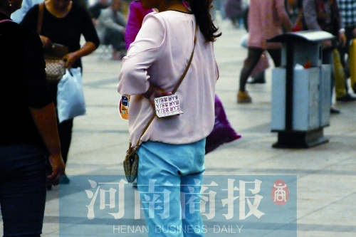 火車站廣場，一女子拿著寫有不同房型價(jià)位的卡片在拉客，不少市民抱怨，受過此類“騷擾”