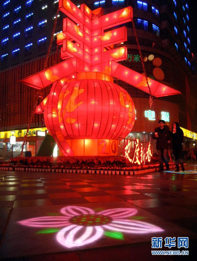 　1月30日晚，市民從蘇州市石路銀河廣場上大型“春”字彩燈景觀旁經(jīng)過。