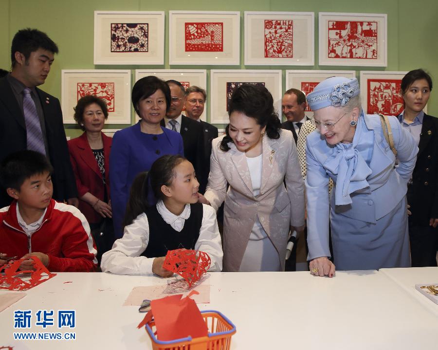 這是彭麗媛和瑪格麗特二世與根據(jù)安徒生童話中人物和情節(jié)制作剪紙的孩子交談。