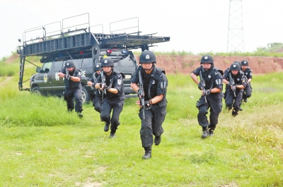 在拍攝現(xiàn)場，特警隊(duì)員下車后快速出擊。記者張琮攝影