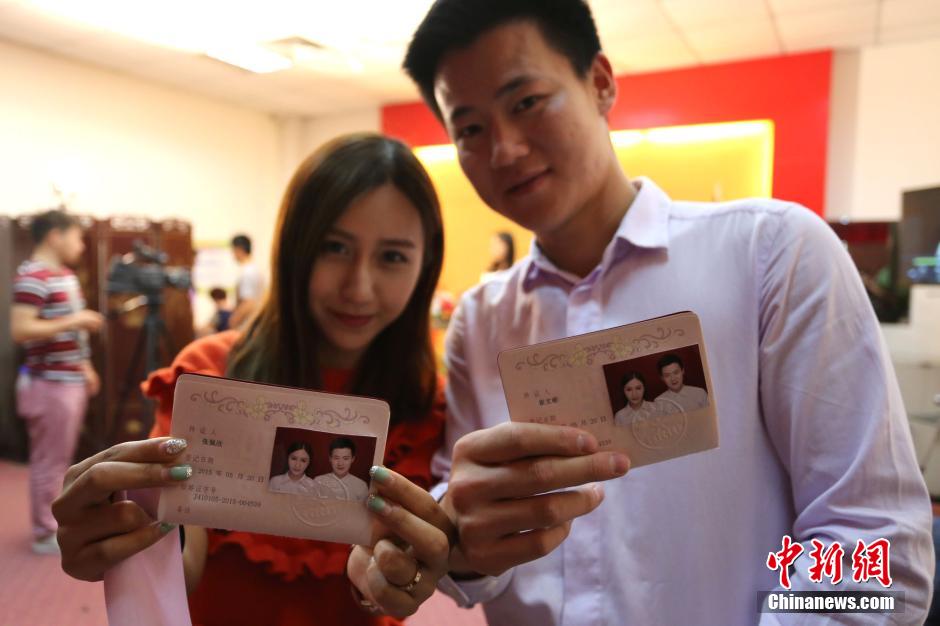 5月20日,河南鄭州,一對(duì)準(zhǔn)新人領(lǐng)完結(jié)婚證后秀自拍。