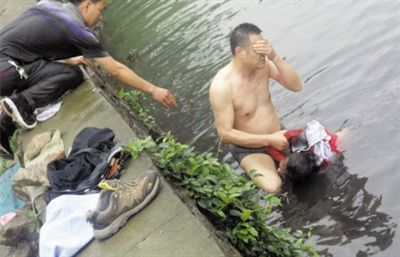 網(wǎng)友貼出民警張光聰一出河水就睜不開眼，用手抹去臉上臟水的照片。