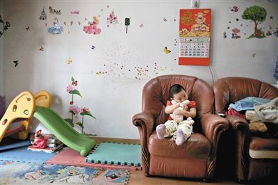 6月14日，未婚媽媽于軍的家里。女兒悅悅抱著兔子玩偶，在聽媽媽手機上的兒歌，這個4歲女孩喜歡兔子。