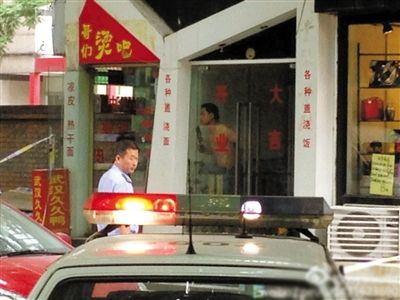 闖入面館的持刀男子與趕來(lái)的民警隔著玻璃門(mén)對(duì)峙，后店內(nèi)一名女童被其劫持。網(wǎng)友供圖
