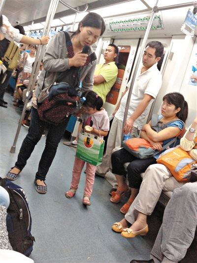 6月27日，舒馨帶一女孩在地鐵十號線行乞。她因被疑帶多個不同小孩乞討被警方搜尋。新京報記者 申志民 攝