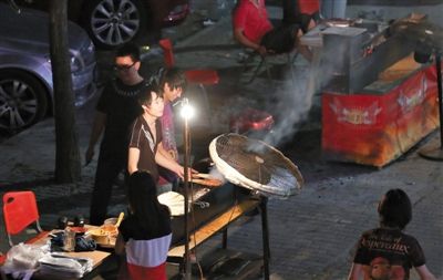 7月4日，青年路國(guó)美第一城小區(qū)附近的夜市臨街露天燒烤攤。