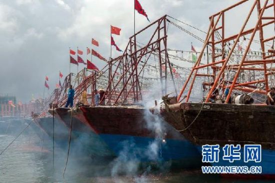 2013年8月1日 南海開漁日 臨高迎新港 8月1日，海南省臨高縣漁民在船上鳴放鞭炮慶祝武蓮港開港。