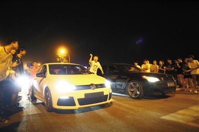 8月24日晚，東壩中街飆車現(xiàn)場(chǎng)，兩輛車并排等待出發(fā)指令，旁邊許多愛好者前來(lái)觀看比賽。新京報(bào)記者