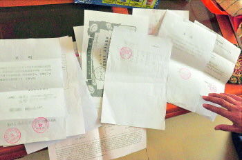 60歲的市民仇先生為了辦理公證所需的這些證明材料,半個月時間里跑了30多趟腿。記者　李萌博　攝