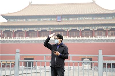 11月1日，北京大部分地區(qū)重度污染，一名游客戴著口罩在午門前揮手跟朋友打招呼。 實(shí)習(xí)生 王飛 攝