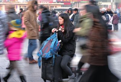 春運(yùn)首日，北京站客流量明顯增多，一名女孩在人流中等待進(jìn)站。