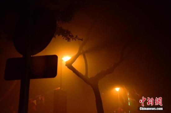 1月31日凌晨，市民行走在煙霧繚繞的南京街頭。當(dāng)天是農(nóng)歷馬年正月初一，南京有限開禁燃放煙花爆竹正逢下霧天，空氣的不流通致使煙花爆竹燃燒后產(chǎn)生的顆粒物不能及時(shí)散開，造成整座城市煙霧繚繞。據(jù)當(dāng)?shù)丨h(huán)保部門發(fā)布的信息顯示，空氣質(zhì)量屬重度污染。中新社發(fā) 泱波 攝