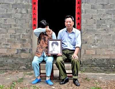 江蘇鎮(zhèn)江，老劉夫婦捧著獨(dú)生子的遺像在老家前留影南方都市報(bào)供圖L