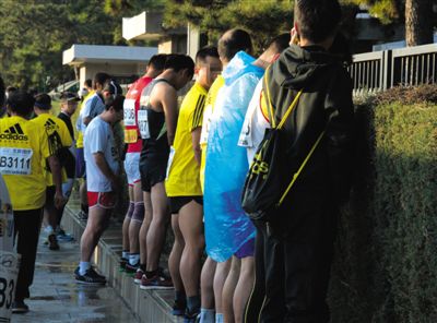 2013年10月20日，北京馬拉松比賽，由于廁位有限，一些選手在綠化帶“就地解決”。圖/IC