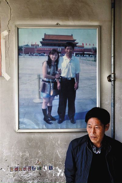 11月14日，承德市平泉縣，潘小梅父母的家，潘小梅父親靠在墻上，身后掛著數(shù)年前他和潘小梅在北京的合影照片。新京報(bào)記者