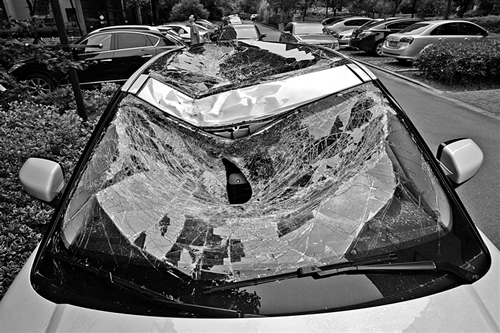 越野車車蓋以及前擋風(fēng)玻璃被砸得凹陷進(jìn)去。見習(xí)記者姚卡/攝