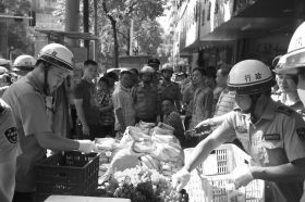 7月11日，瀏陽市北正中路，執(zhí)法人員暫扣張海的水果。這是瀏陽市城管局拍攝的執(zhí)法現(xiàn)場圖。