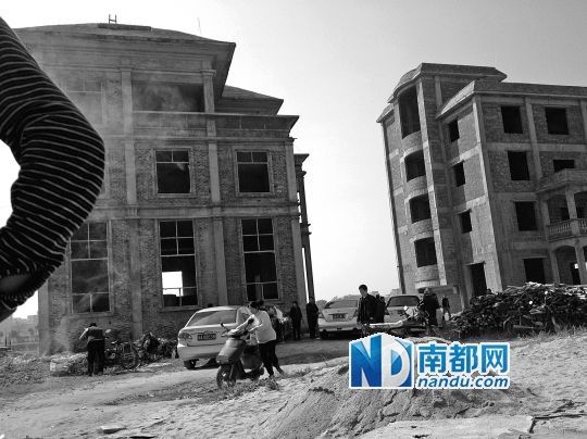 兩棟被舉報(bào)的違建樓下昨日一度聚集了超過(guò)百人，城管離開(kāi)后逐漸散去。南都記者張志韜實(shí)習(xí)生宋超攝