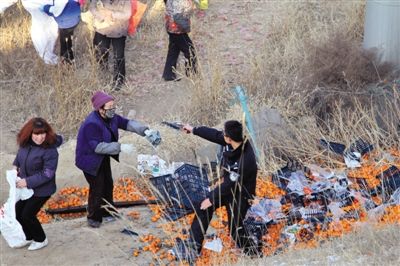 1月4日，連霍高速蘭州市榆中縣和平鎮(zhèn)段，一名警察舉著槍驅(qū)散哄搶橘子的村民。圖/CFP