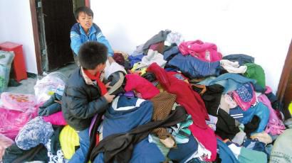學生在幫忙整理收到的捐贈衣服。得石中心校供圖