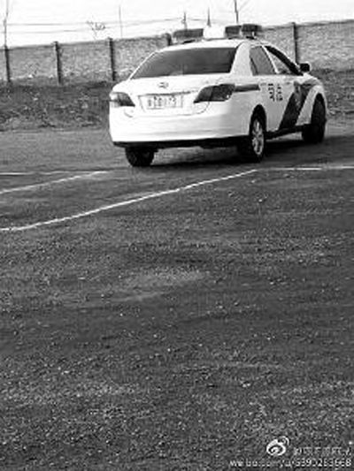 一輛車牌號 為“ 陜DD173”的制式警車停在一個劃著白線的場地上，車身標(biāo)有“司法”字樣