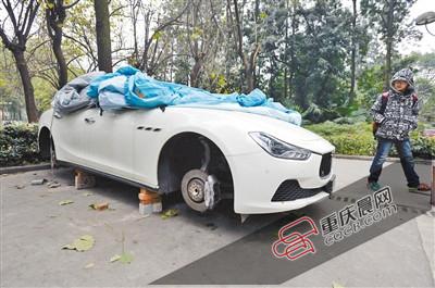 昨日，停放在重慶大學(xué)B區(qū)的一輛瑪莎拉蒂豪車被架在幾塊磚頭上，車輪不翼而飛。 重慶晨報(bào)記者 胡杰 攝
