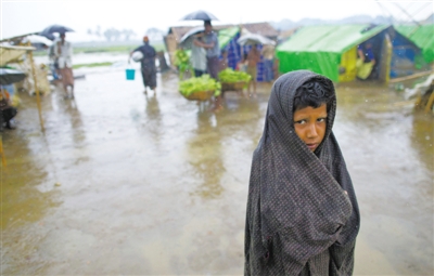 5月14日，緬甸若開邦實(shí)兌難民營(yíng)，羅興亞族難民在雨中行走。熱帶風(fēng)暴“馬哈森”即將登陸緬甸，這里的難民開始乘船撤離。