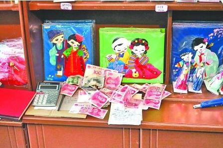 　　2012年6月21日，在朝鮮羅先特別市的一家商店里，柜臺(tái)上散落著一些人民幣。在朝鮮，人民幣比本國(guó)