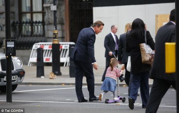 英國(guó)首相卡梅倫步行送女兒上幼兒園。
