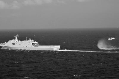 11日，抵達(dá)馬航飛機(jī)失聯(lián)海區(qū)的海軍井岡山艦與艦載直升機(jī)協(xié)同展開立體搜救行動(dòng)。新華社發(fā)