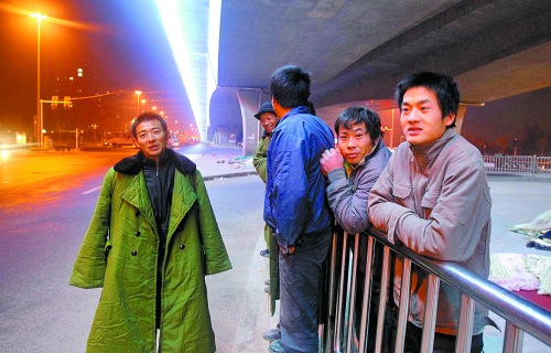 冬夜里，農(nóng)民工在橋下等著干活兒。