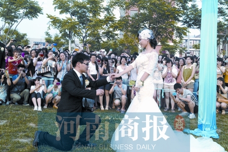 在學(xué)校操場的草坪上，兩名畢業(yè)生舉行婚禮，有同學(xué)感動地抹起眼淚