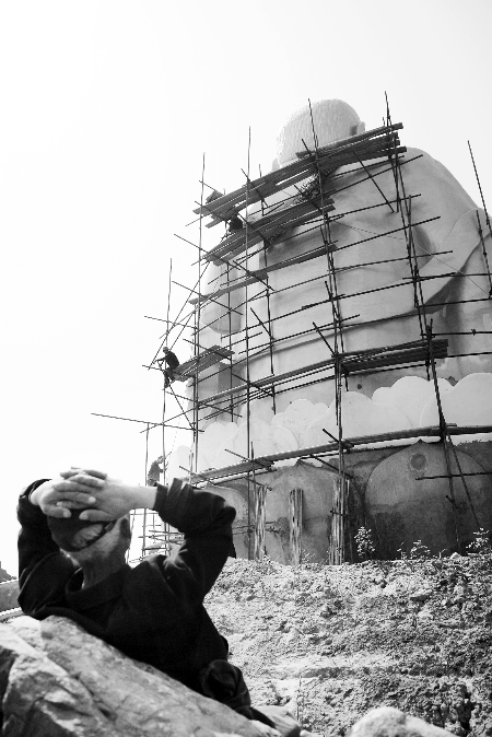 今年4月26日，工作人員將帆布蓋在“佛像”頭像上