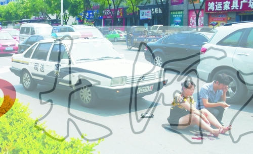 事故發(fā)生后，警車司機(jī)（右）下車查看傷者并撥打120，倆“領(lǐng)導(dǎo)”穩(wěn)坐車內(nèi)引發(fā)圍觀者不滿。