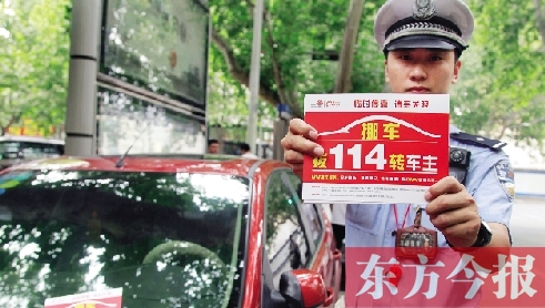 8月27日，鄭州市緯一路與經(jīng)七路交叉口，交警將“挪車請撥打114轉(zhuǎn)車主”的提示牌放在路邊?？康能嚿? width=