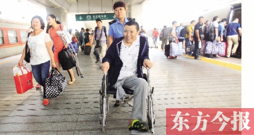 李剛手術(shù)后歸來，在車站工作人員幫助下走出鄭州火車站站臺  東方今報首席記者 張曉冬 攝