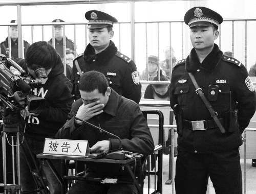 庭審中,29歲的李軍低著頭。