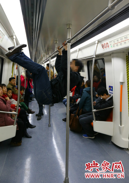地鐵試乘日，一男子在車廂內(nèi)攀爬扶手自娛自樂